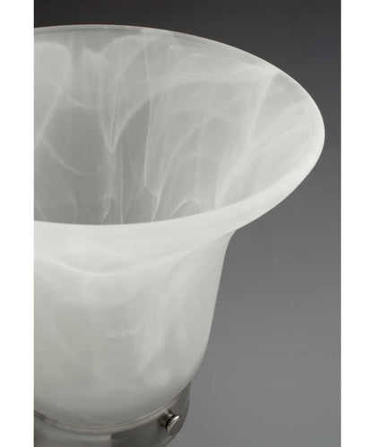 Close-up of alabaster glass shade from brushed nickel bath vanity light, showcasing soft, diffused glow effect.